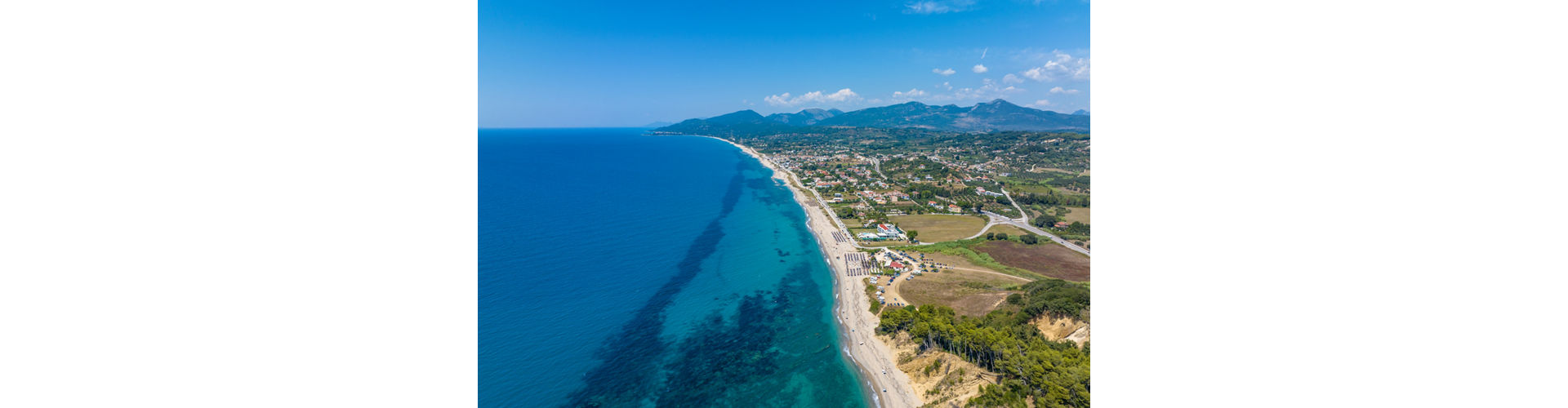 A serene path winding through trees and bushes, leading to a beautiful beach in Kanali.