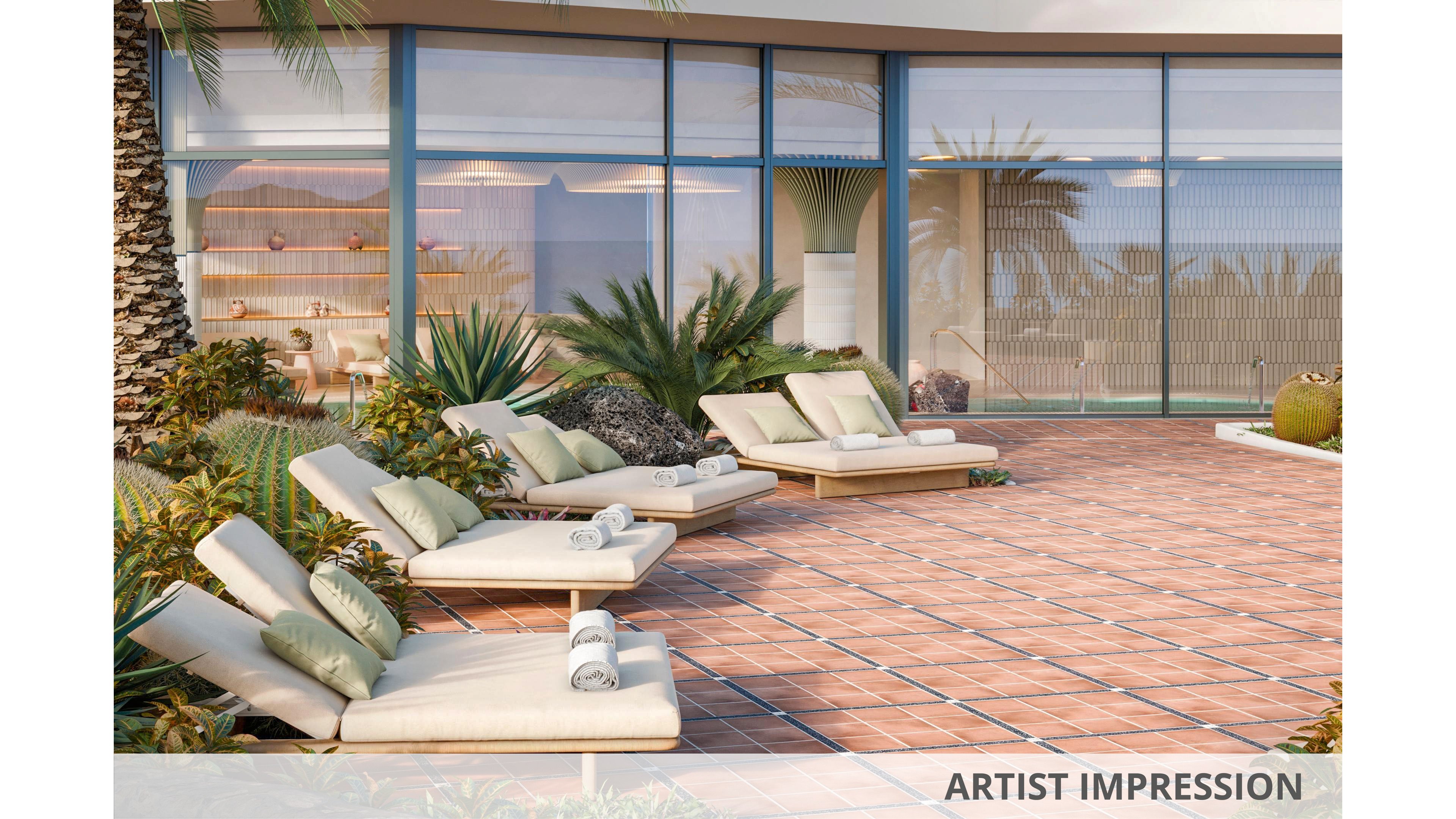 Artist impression of a contemporary resort terrace featuring several cushioned sun loungers arranged on a tiled patio. The setting includes lush tropical plants and palm trees surrounding the outdoor relaxation area. Large glass windows and sliding doors reveal a stylish interior with shelves and decor elements. Warm sunlight and soft neutral tones create a calm, inviting vacation atmosphere.