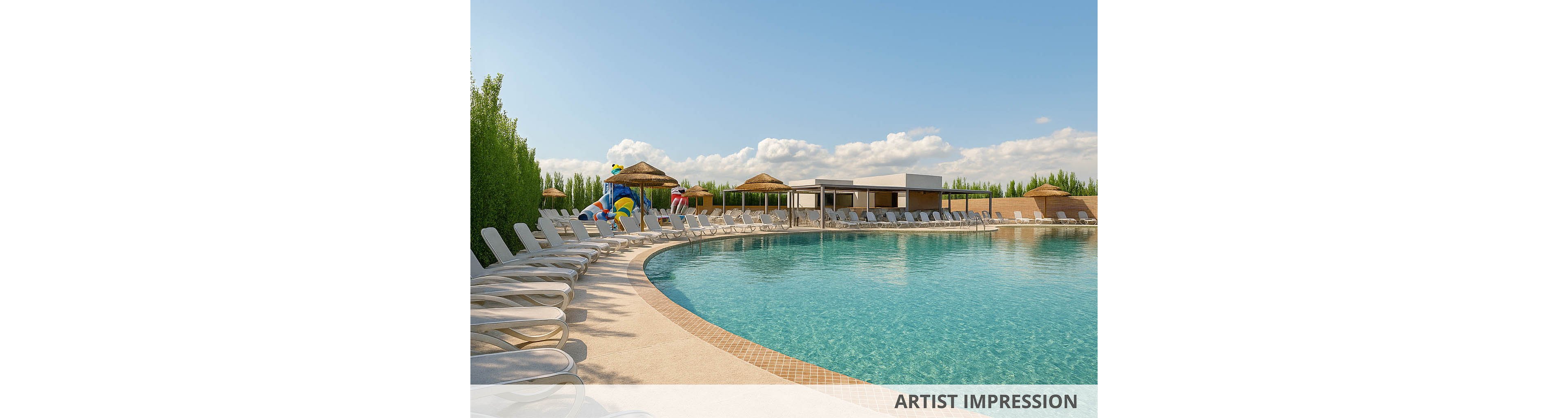 A large curved swimming pool is surrounded by rows of empty white lounge chairs under a clear blue sky. The resort-style setting includes thatched umbrellas, cabanas, and a poolside bar area in the background. Lush green hedges frame the scene, adding privacy and a natural border around the water. The calm, turquoise pool and bright daylight create a relaxed, vacation-like atmosphere.