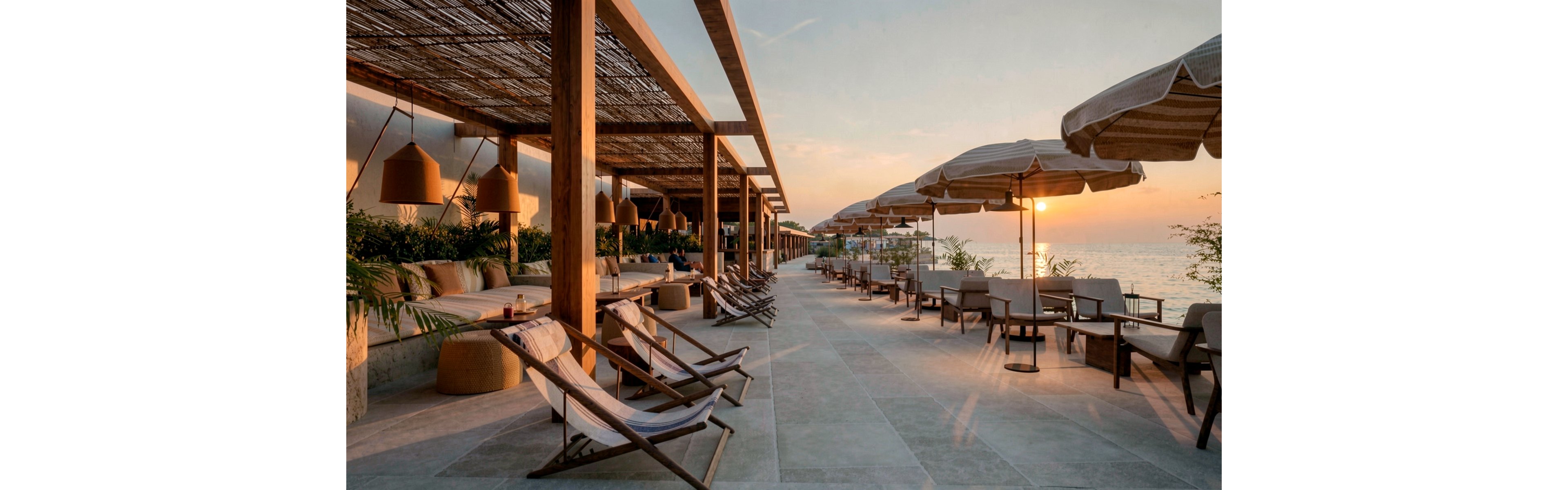 An upscale beachfront lounge terrace is shown at sunset, featuring rows of wooden sunbeds and cushioned seating under pergolas. Large woven pendant lights and natural wood structures create a warm, contemporary coastal atmosphere. Umbrellas line the edge of the terrace facing the calm sea and glowing horizon. Lush greenery softens the modern architecture, enhancing the relaxed vacation setting.