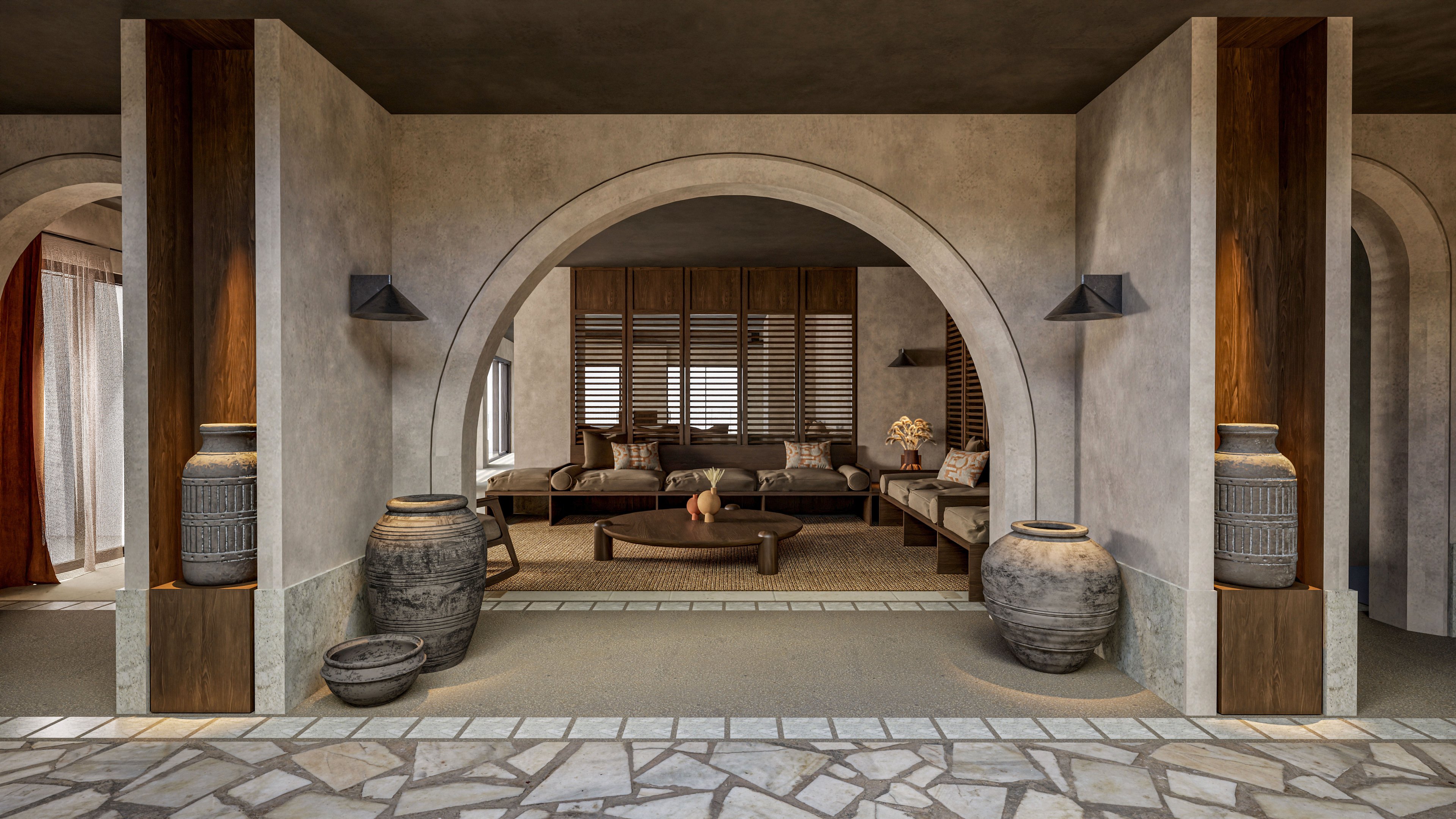 A contemporary lounge area is framed by a large stone archway and textured concrete walls. Low wooden seating with neutral cushions is arranged around a central coffee table, creating a relaxed social space. Large decorative clay urns and vases stand on either side of the arch, adding rustic character. Warm wood paneling, window blinds, and soft ambient lighting contribute to a cozy, Mediterranean-inspired interior atmosphere.