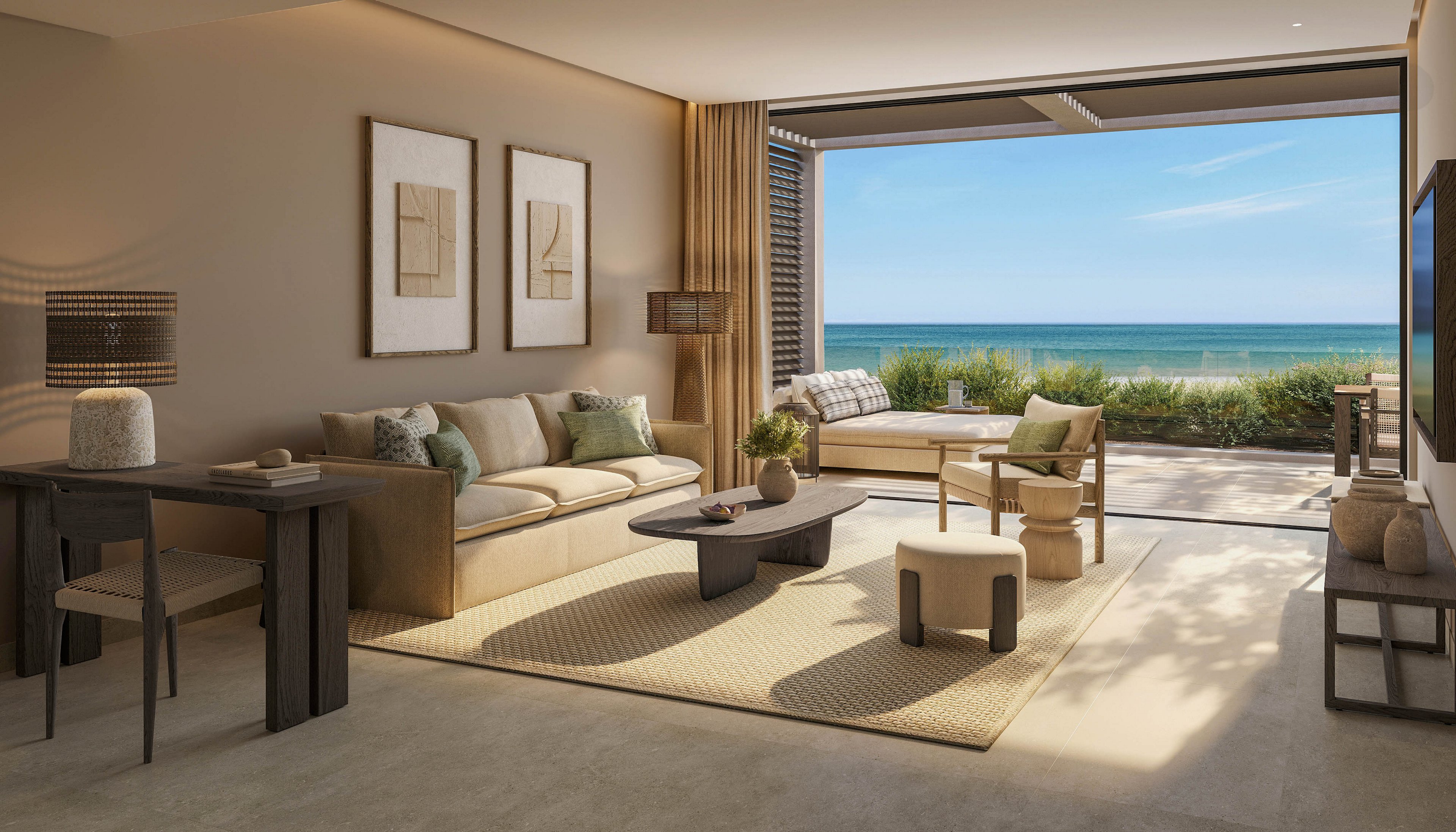 A contemporary living room opens directly to a terrace overlooking a calm ocean. Neutral-toned sofas, armchairs, and a low coffee table create a relaxed seating area. Large wall art, soft lighting, and minimalist decor emphasize a warm, natural aesthetic. Floor-to-ceiling opening frames the blue sky, sea, and greenery outside, blending indoor comfort with outdoor scenery.