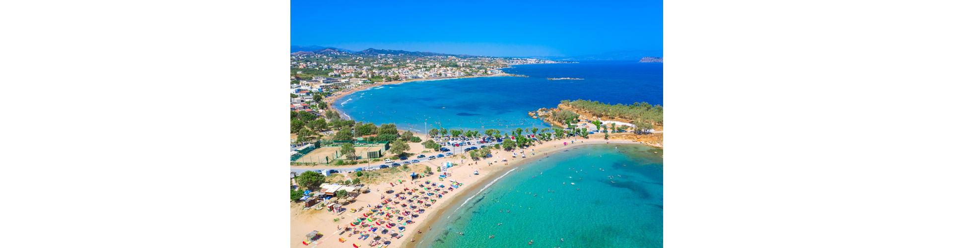 A Greek salad with peppers, olives, and bread, accompanied by a glass of wine, set against a seaside background in Kato Daratso.