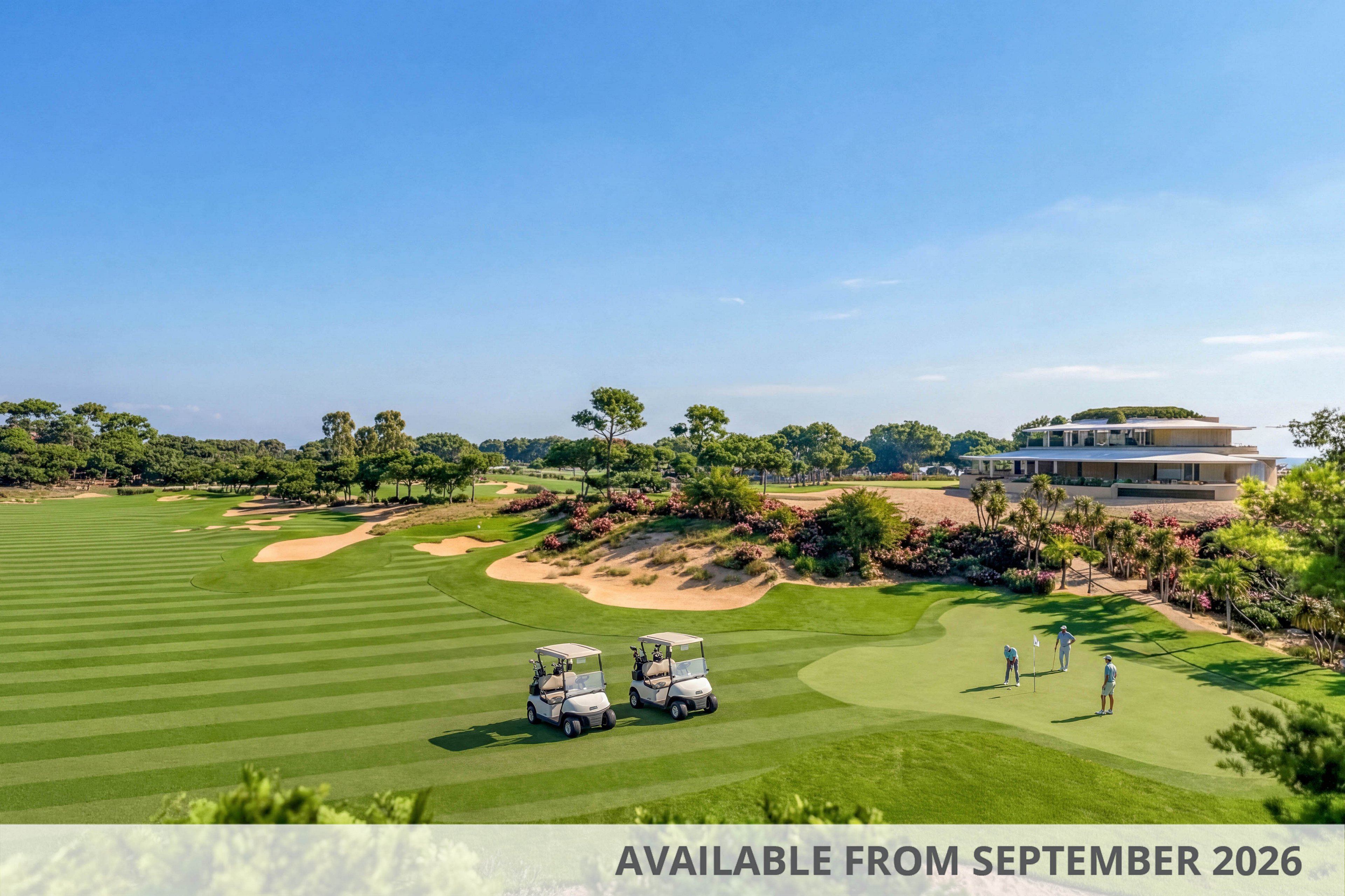 A wide view of a manicured golf course shows two golf carts parked on the fairway and several golfers preparing their shots. The scene includes neatly striped grass, sand bunkers, and landscaped greenery under a clear blue sky. A modern clubhouse stands in the distance surrounded by trees and flowering shrubs. The bright daylight and open landscape create a relaxed, leisurely atmosphere.
