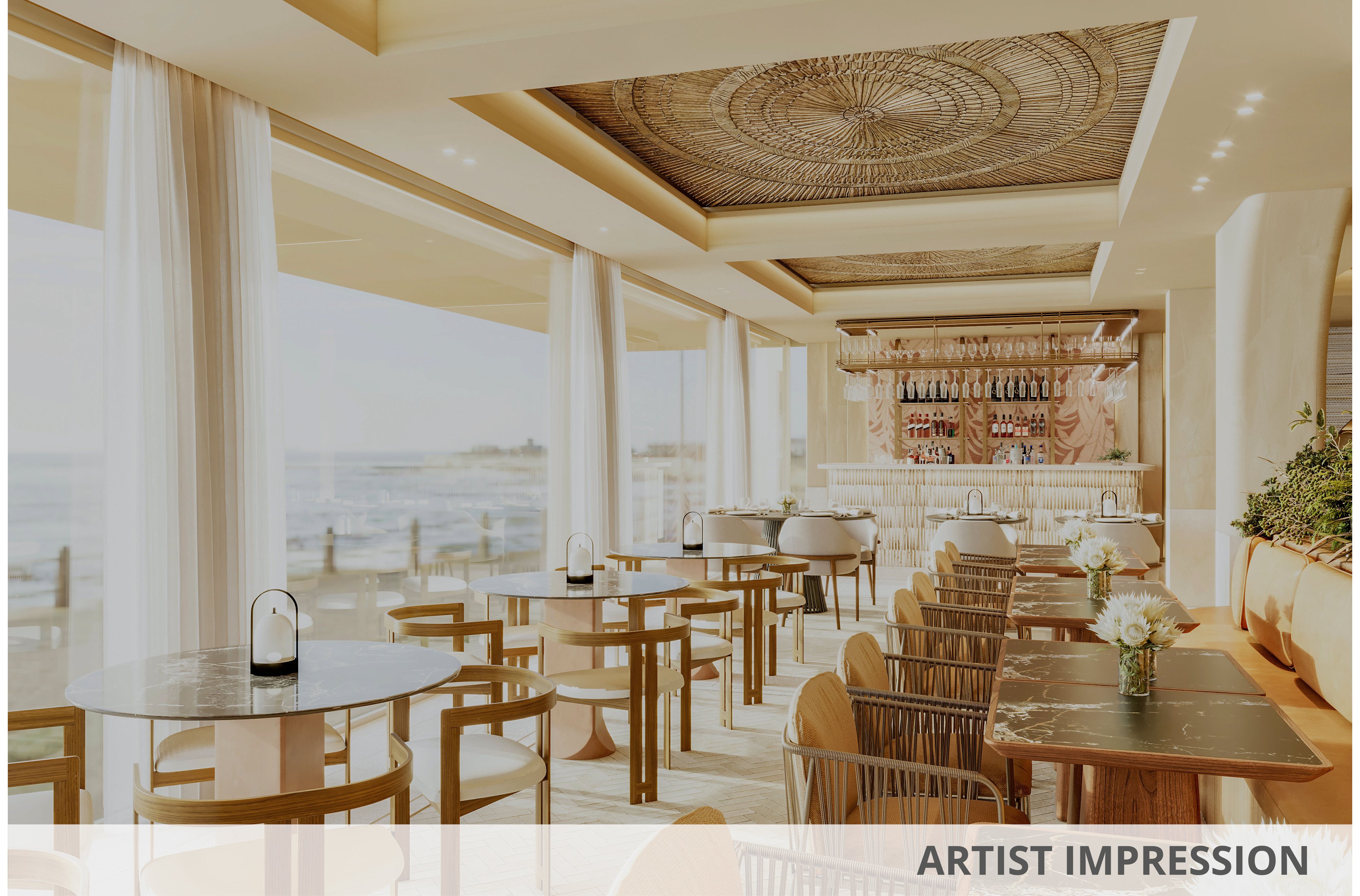 Bright, modern restaurant interior overlooks a coastal ocean view through large floor-to-ceiling windows. Wooden tables and contemporary chairs are neatly arranged, leading toward a stylish bar area with hanging glassware and bottles. Sheer white curtains, light neutral tones, and soft natural lighting create an airy, relaxed atmosphere. Decorative ceiling details and fresh flowers on the tables add an elegant, upscale touch to the dining space.