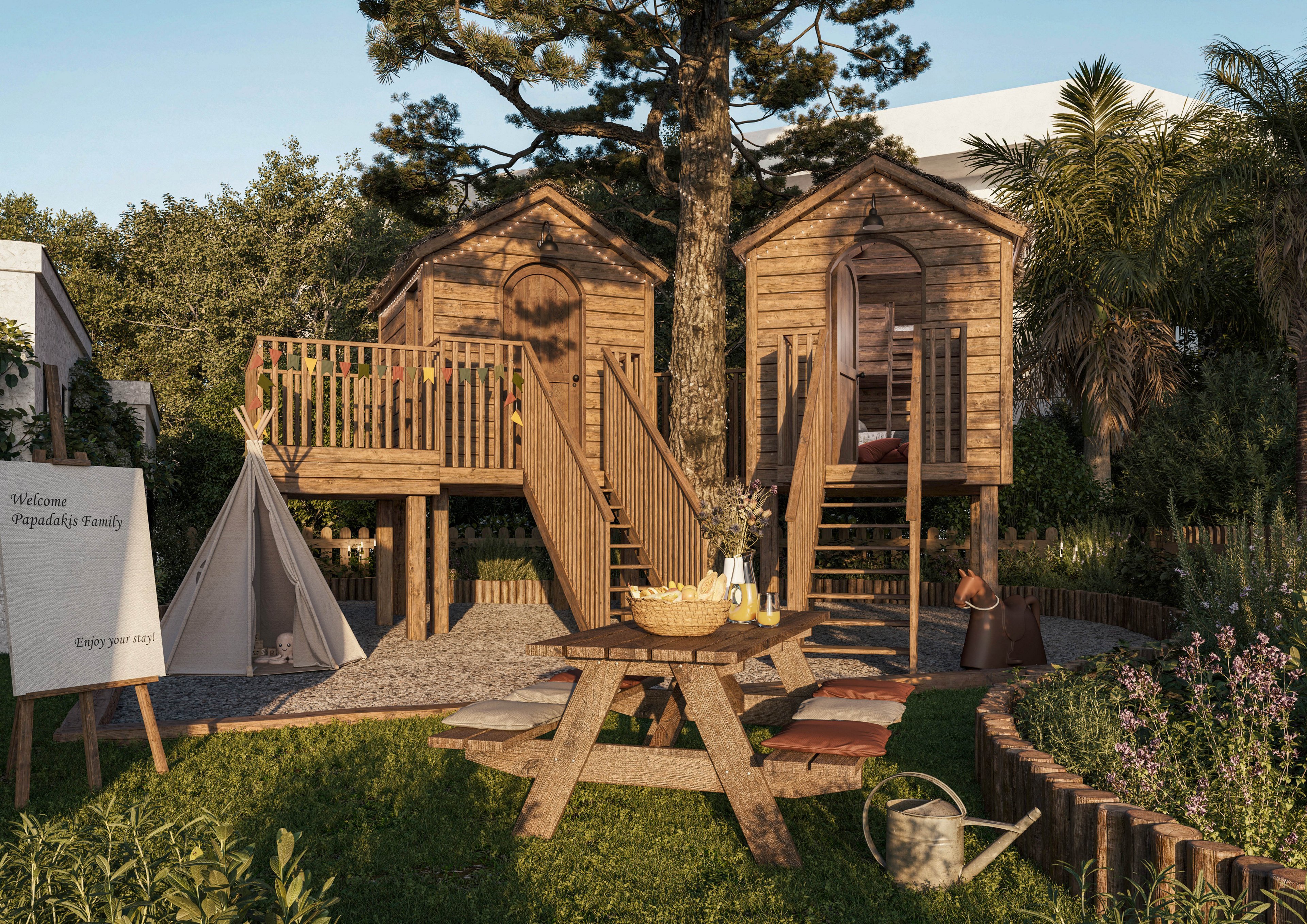 A pair of elevated wooden treehouses stand around a large tree in a lush backyard setting. A picnic table with a basket, drinks, and lanterns sits in the foreground beside a small vegetable garden and watering can. A white teepee tent and a wooden signboard reading “Welcome Playada’s Family” and “Enjoy your stay” add a welcoming, family-friendly touch. Warm evening light and abundant greenery create a relaxed, rustic outdoor atmosphere.