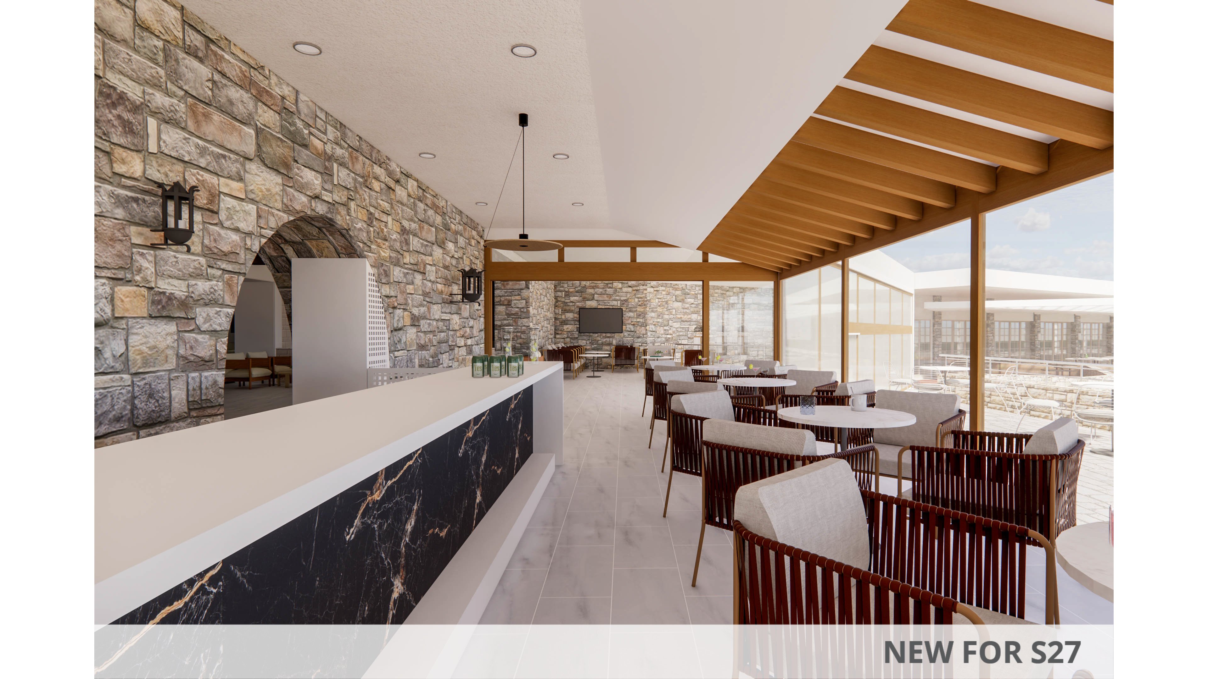 A contemporary resort lounge bar features a long marble-front counter set against a rustic stone wall. Wooden chairs and round tables are arranged neatly along large floor-to-ceiling windows overlooking an outdoor terrace. Warm wood ceiling beams and neutral tile flooring create an inviting, airy atmosphere. The space appears bright and relaxed, ideal for casual dining or drinks with a view.
