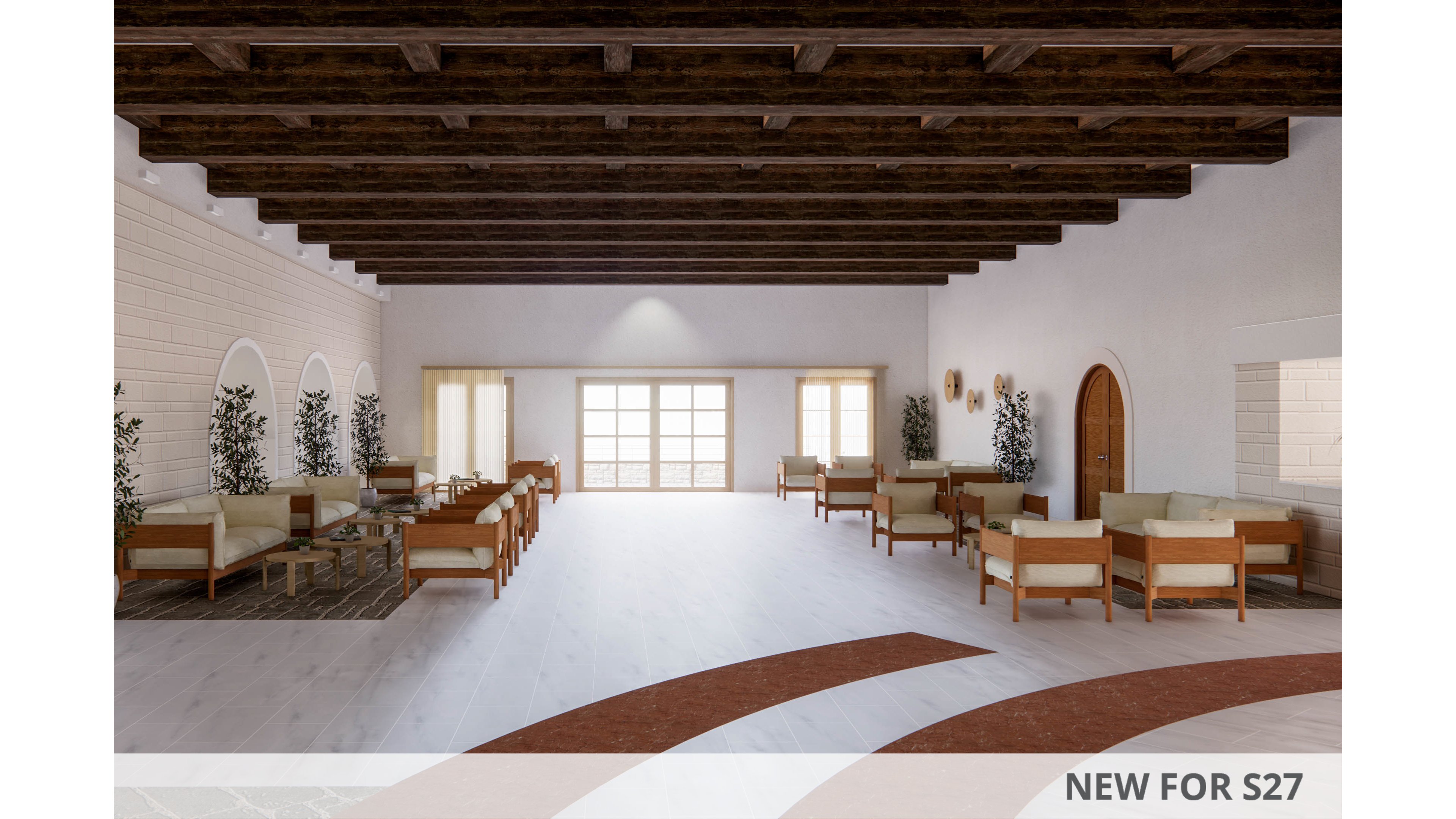 A large, open lounge features multiple wooden chairs and sofas arranged along the walls. The space has light-colored floors, white brick walls, and a dark exposed-beam ceiling. Large windows at the far end let in bright natural light, illuminating potted plants and simple decor. The overall atmosphere is calm, airy, and minimalist, suitable for social gatherings or relaxation.