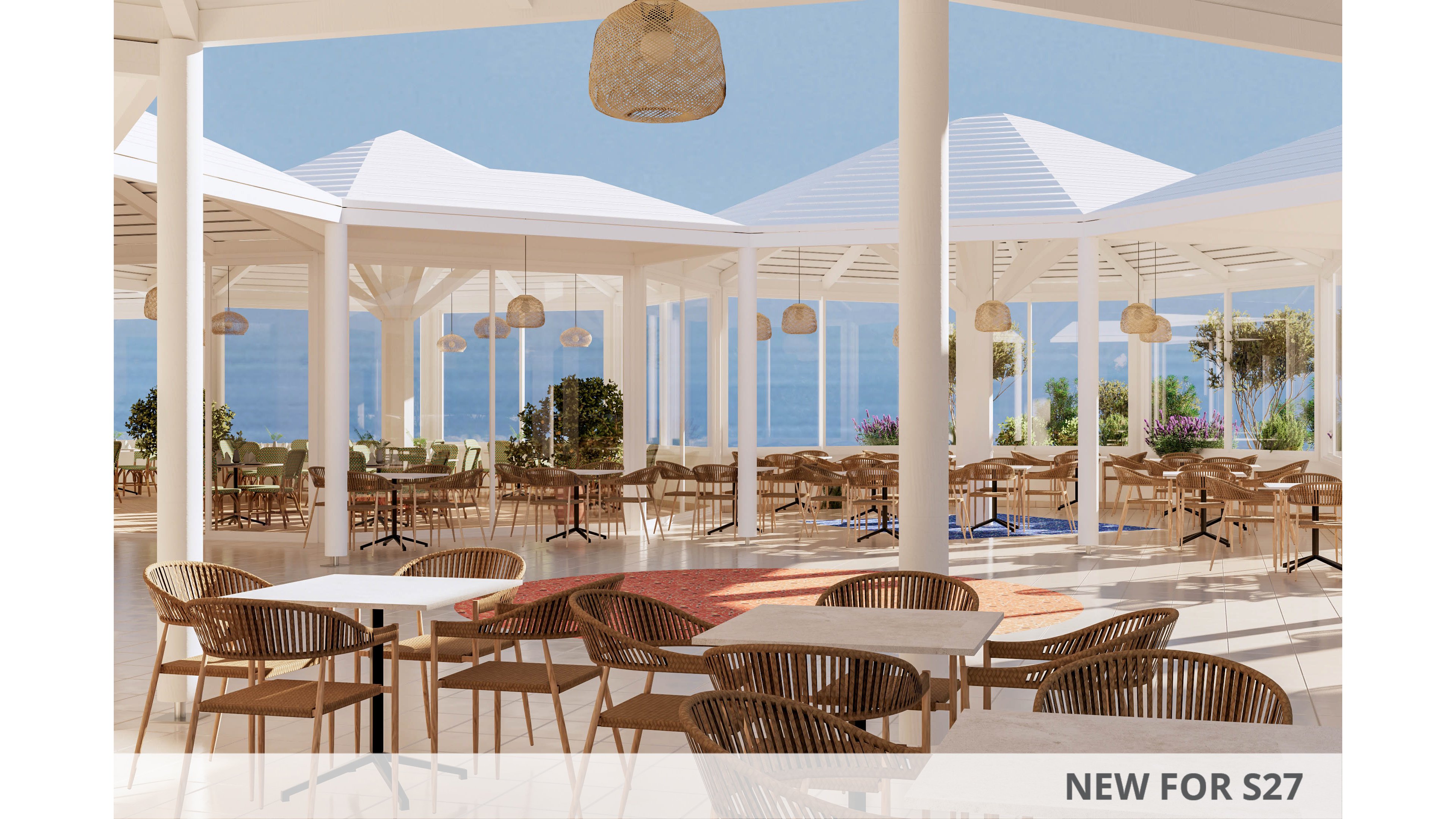 An open-air restaurant terrace features numerous wicker chairs and light-colored tables arranged under white pergola-style roofs. The setting overlooks a calm blue sea, with clear skies and distant coastline visible in the background. Natural light floods the space, highlighting neutral tones, wooden textures, and hanging woven pendant lamps. The overall atmosphere feels relaxed, airy, and ideal for coastal dining or leisurely gatherings.
