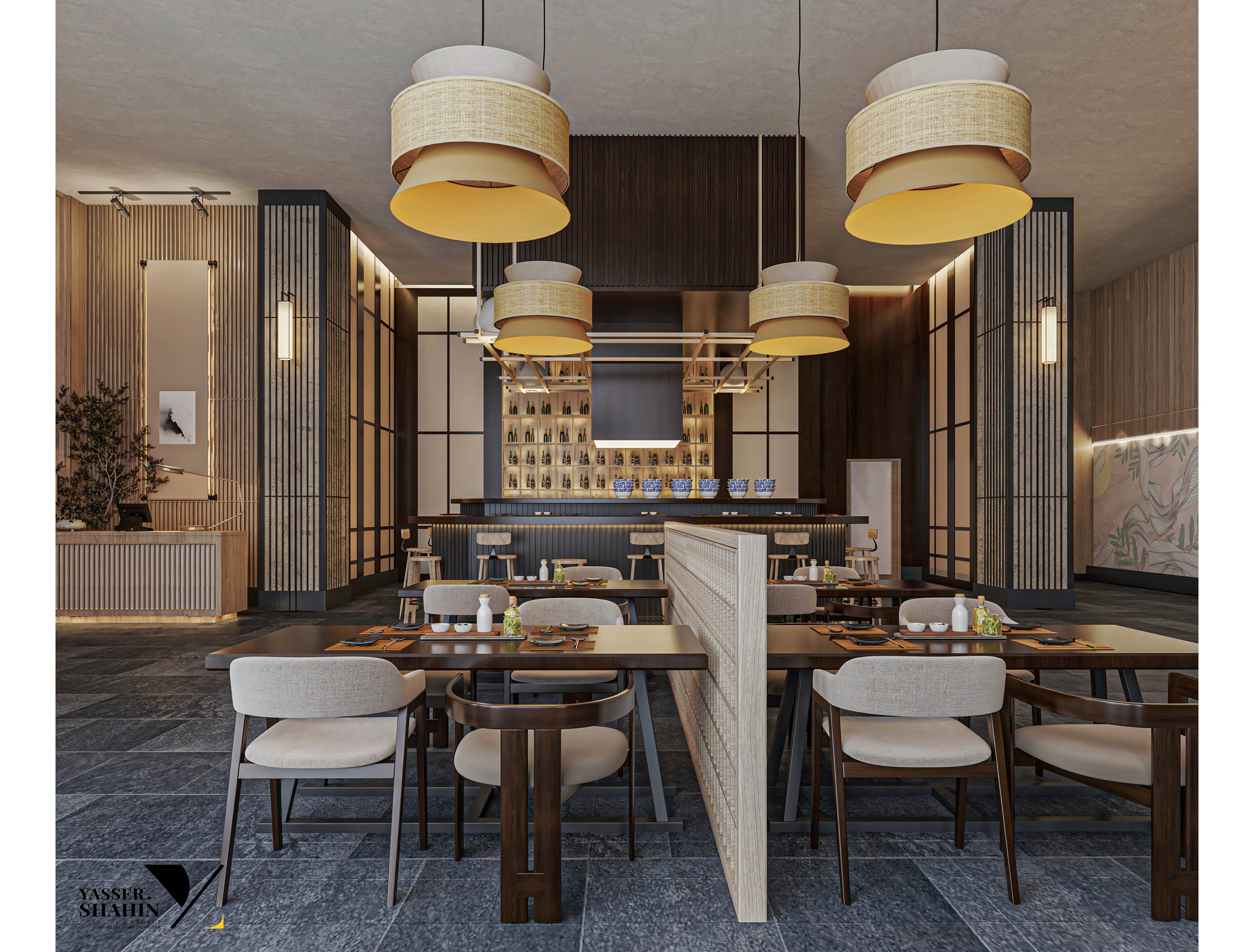 A contemporary restaurant dining area features stylish pendant lights and a central bar. The setting includes wooden tables, cushioned chairs, and a partition dividing the seating space. Warm neutral tones and soft lighting create a welcoming, upscale atmosphere. Decorative wall panels and a visible bar area enhance the sophisticated design. The image includes a visible 'Yassel Methal' text in the lower left corner.