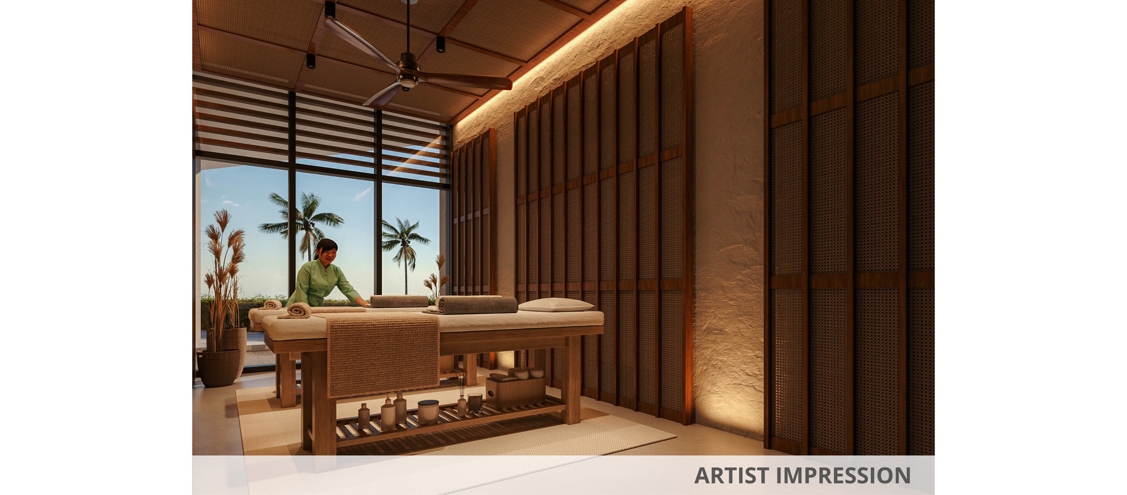 A therapist prepares a massage table in a luxurious spa treatment room. Warm ambient lighting highlights the wooden walls, floor, and built-in shelving beneath the table. Large windows open to a view of palm trees and an evening sky, suggesting a tropical resort setting. Neatly arranged spa accessories and towels create a calm, organized atmosphere ideal for relaxation.