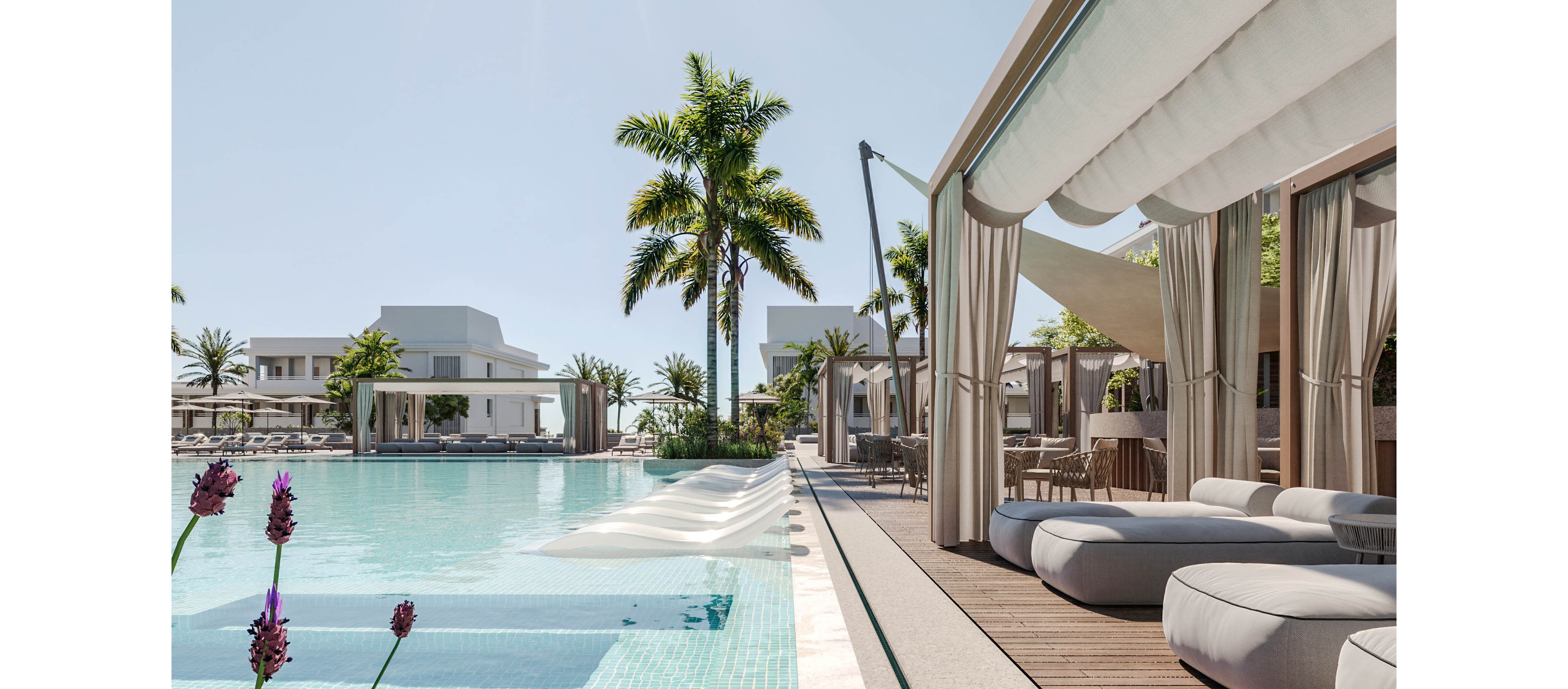 A modern luxury resort pool is lined with shaded cabanas and cushioned loungers. Palm trees and contemporary white buildings frame the serene outdoor setting under a clear sky. The turquoise water of the swimming pool features in-pool loungers and a clean tiled edge. Soft neutral fabrics and wooden decking create a minimalist, upscale atmosphere ideal for relaxation.