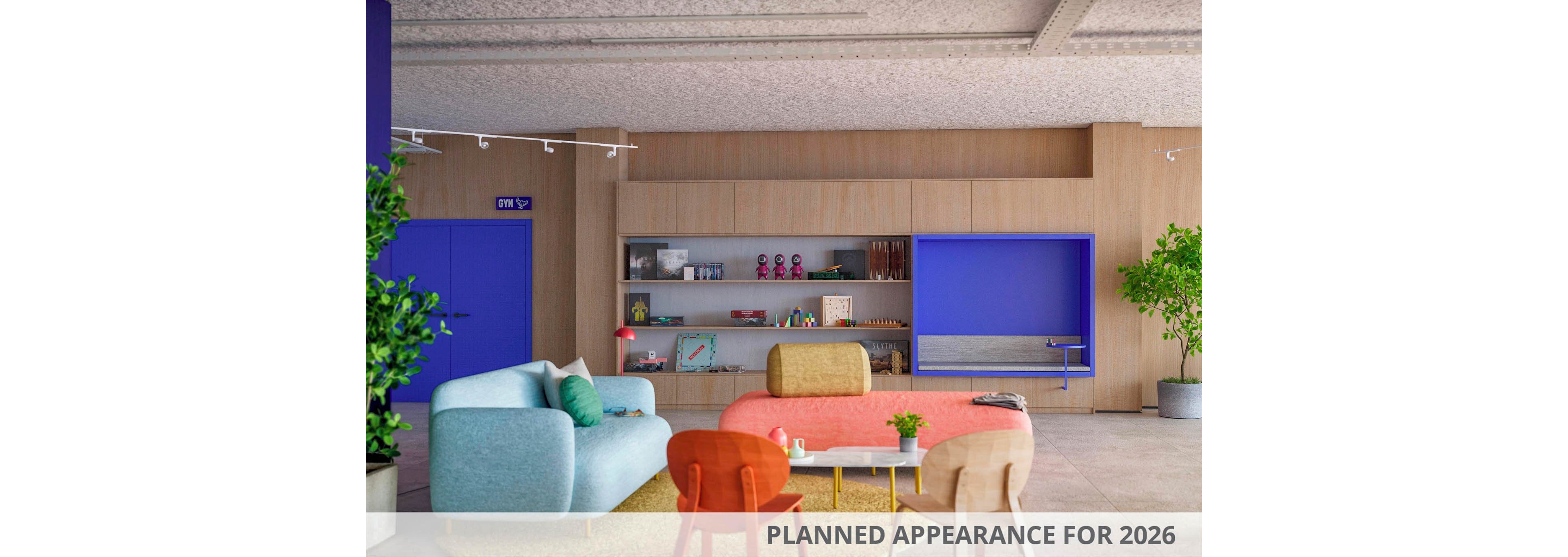 A contemporary lounge area featuring colorful furniture, including sofas and chairs in red, blue, and beige tones. The setting includes wooden shelving with decorative items and a bright blue accent wall. Visible text reads 'PLANNED APPEARANCE FOR 2026,' indicating a future design concept. The space is complemented by indoor plants and a clean, open layout.