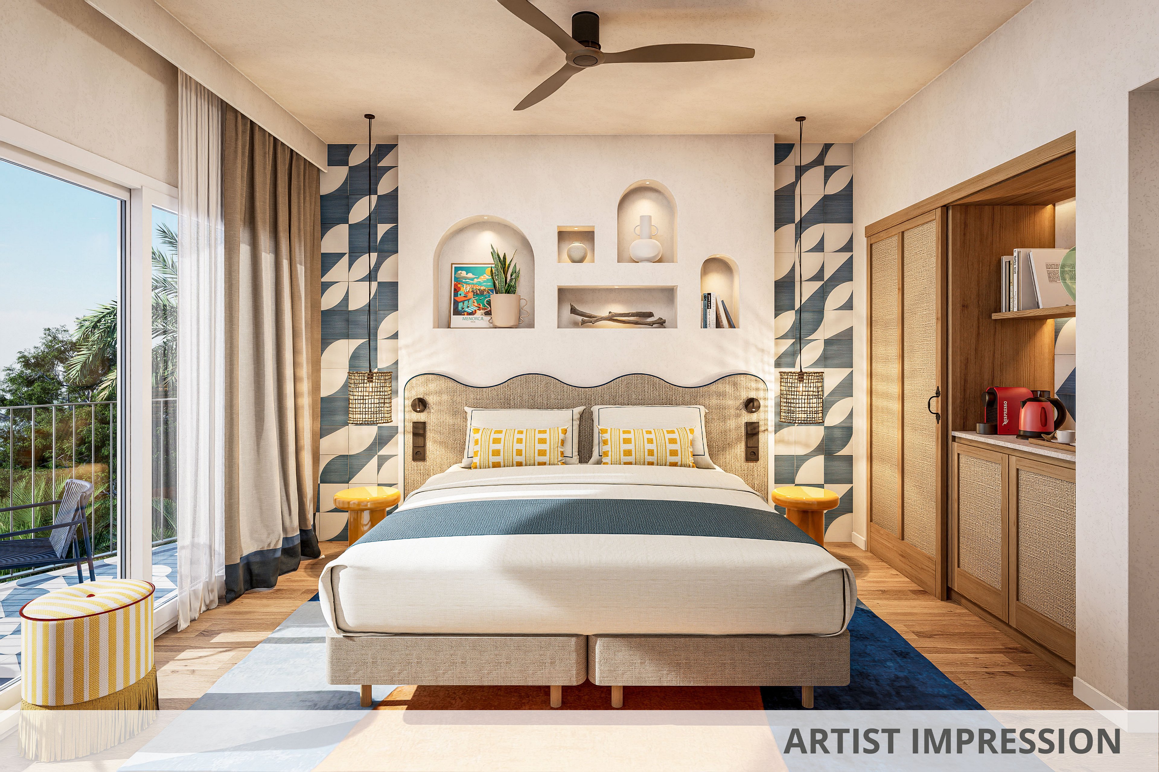 Stylish contemporary bedroom features a double bed with patterned pillows and a curved headboard. Built-in wall niches display decor items, framed by bold geometric blue and white panels. A ceiling fan, bedside tables, and a small kitchenette with appliances complete the cozy interior. Large glass doors open to a balcony, allowing natural light to fill the warm, inviting space.