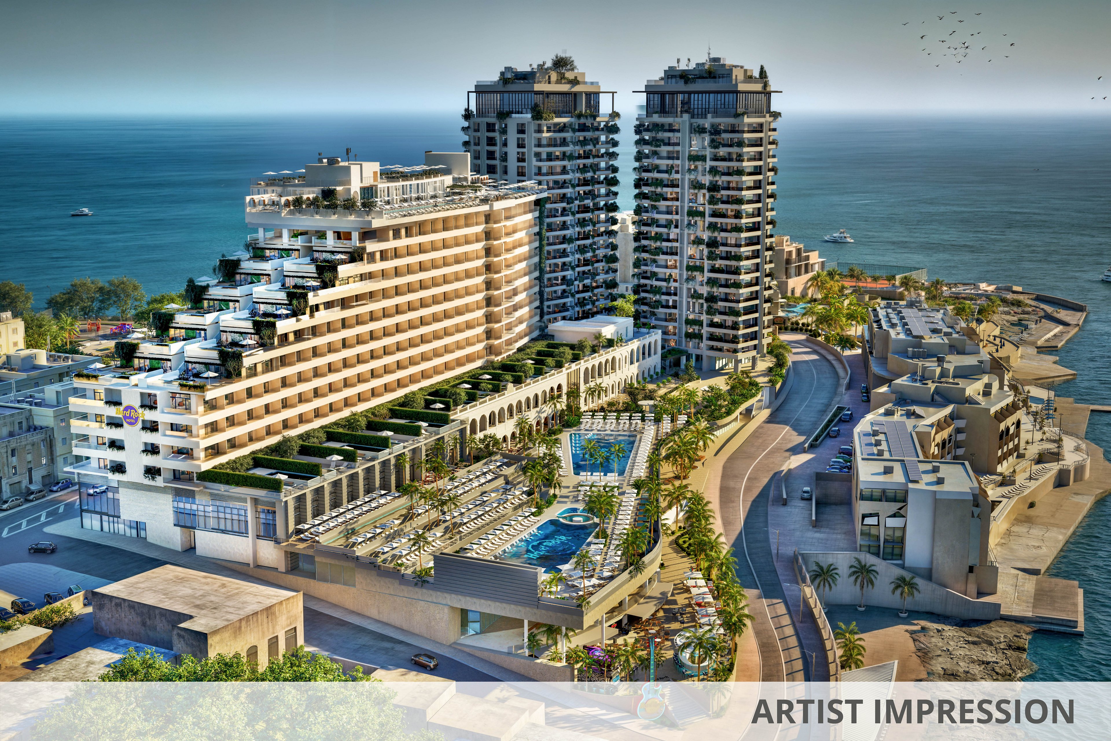A large, contemporary resort complex is situated along a scenic coastline, featuring two high-rise towers and a stepped main building. The setting includes multiple outdoor swimming pools, palm trees, and sun loungers, with the ocean and boats visible in the background. The architecture is modern, and the mood is vibrant and luxurious, suggesting a popular vacation destination.