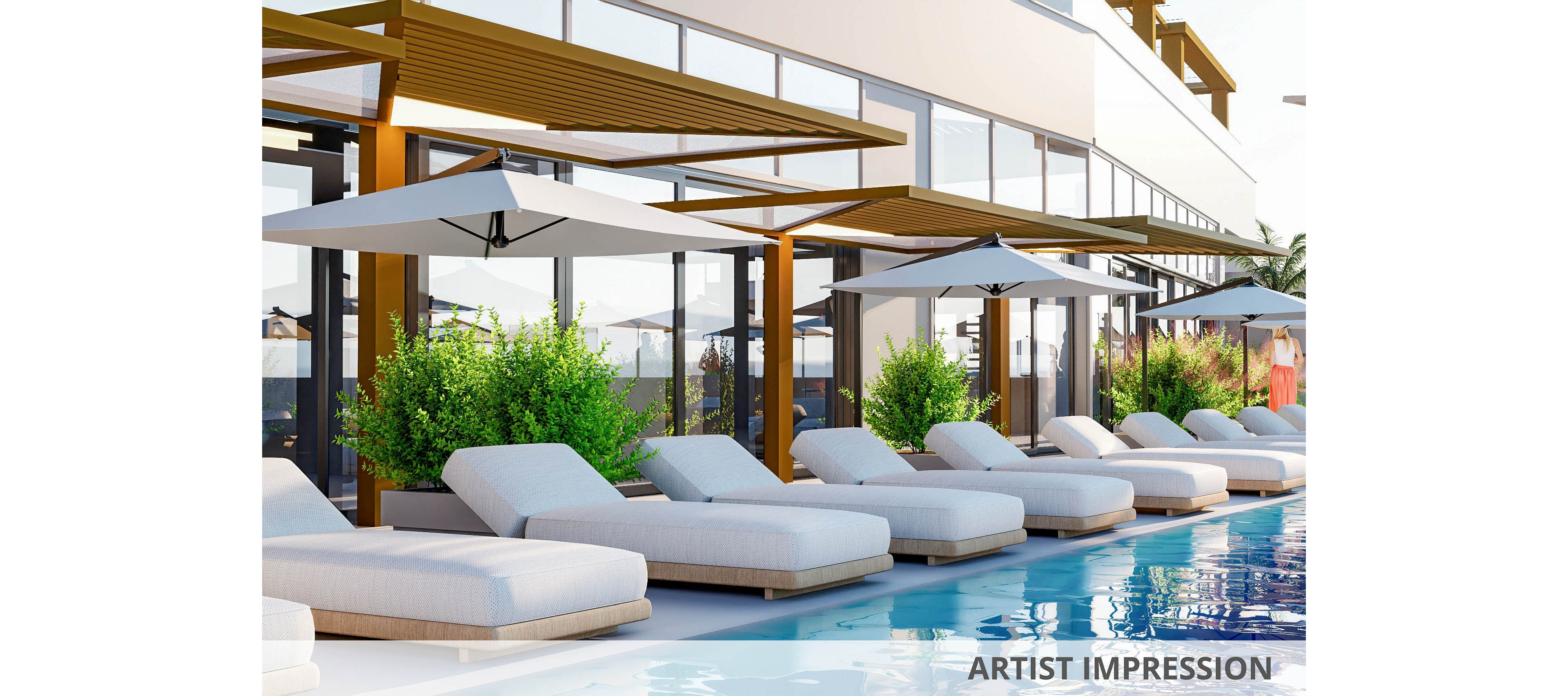 A row of white cushioned lounge chairs is arranged beside a clear blue swimming pool, each shaded by large white umbrellas. The setting is outdoors, adjacent to a modern glass-fronted building with wooden pergolas and lush green plants. The scene is bright and inviting, evoking a relaxed, luxurious vacation atmosphere.