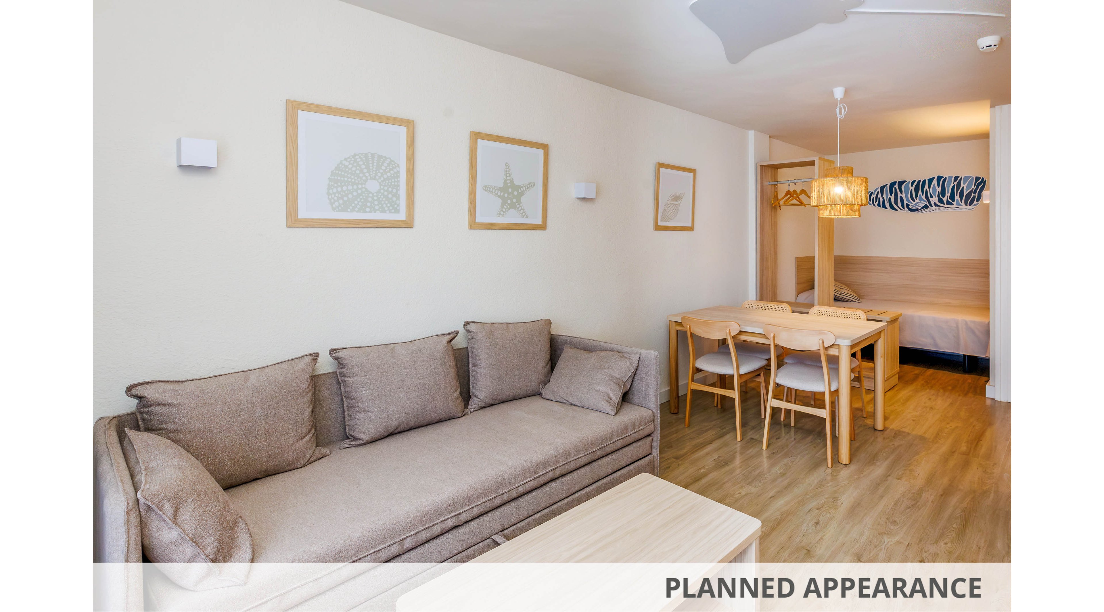 A contemporary living room features a beige sofa with matching cushions and a light wood coffee table. The space is decorated with framed sea-inspired artwork and a dining area with wooden chairs and a pendant lamp. The room extends to a visible bed area, all unified by a soft, neutral color palette and clean lines.