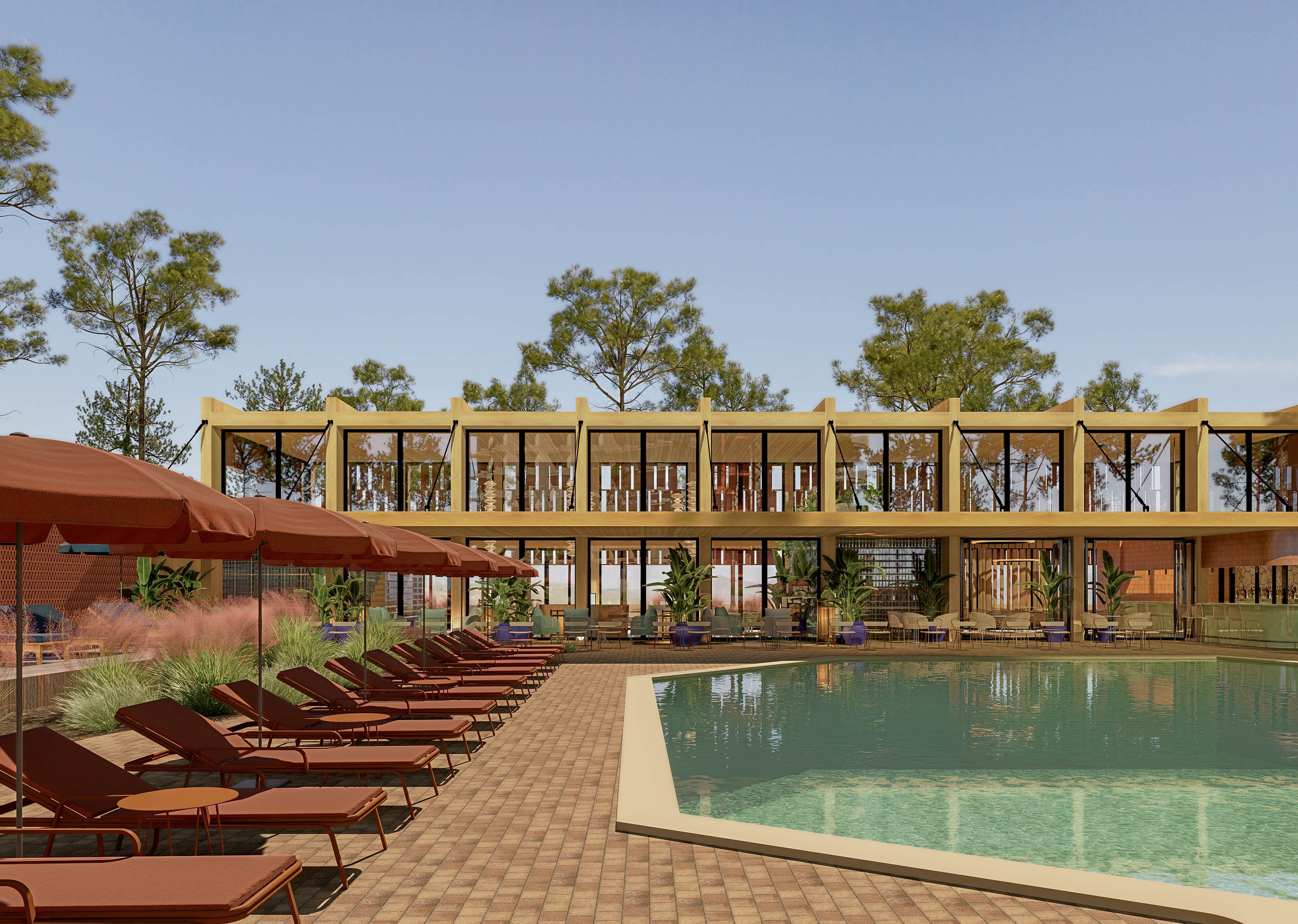 A contemporary resort-style building overlooks a large outdoor swimming pool. Numerous brown sun loungers line the tiled deck under matching umbrellas, creating a relaxed vacation atmosphere. Tall trees surround the structure, adding greenery and framing the open, glass-fronted architecture. The clear sky and calm water suggest a warm, tranquil day at a leisure destination.