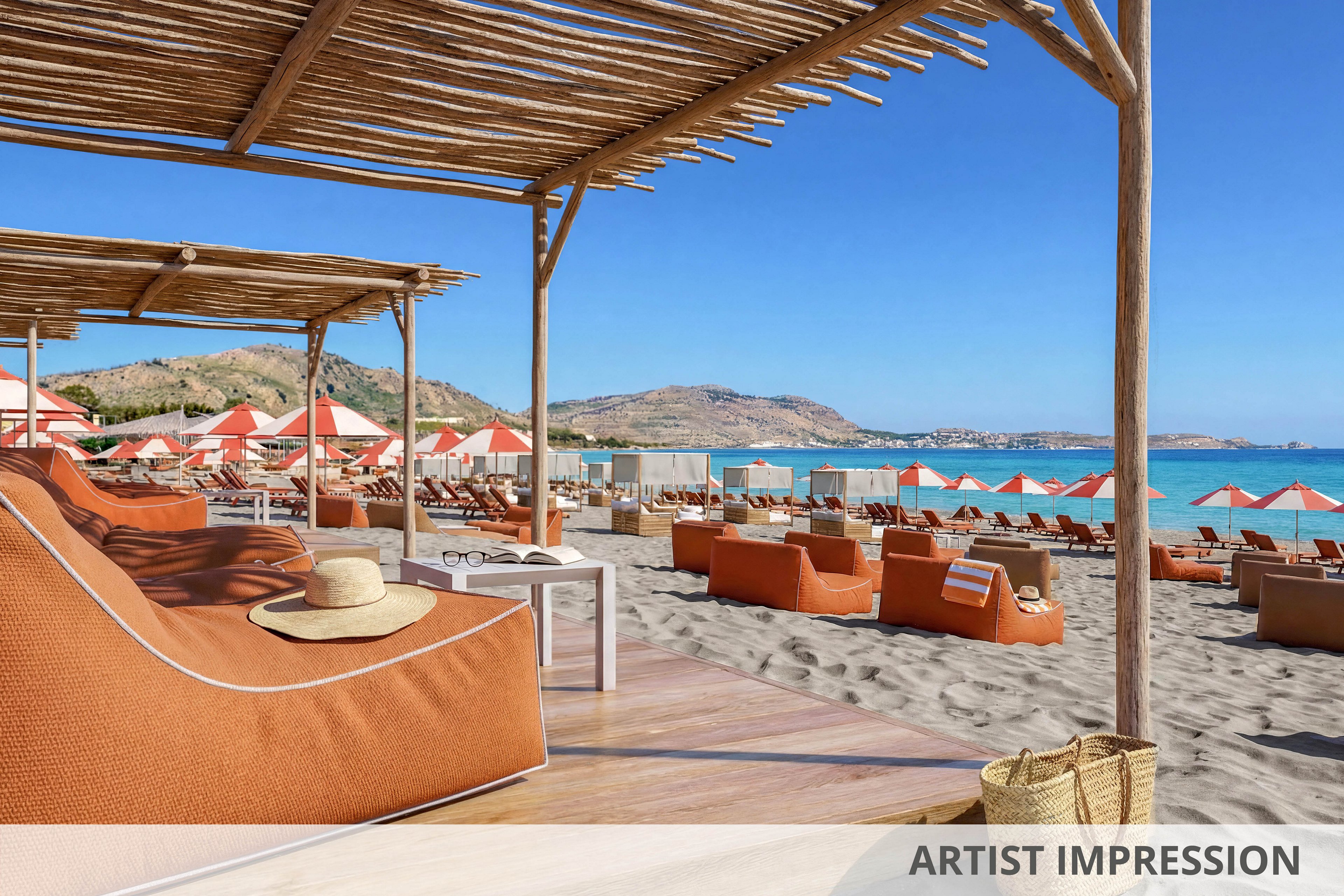 A stylish beachfront lounge area features large cushioned sunbeds under a wooden pergola. Rows of matching orange loungers and umbrellas extend along the sandy shore toward the turquoise sea. The sky is clear and blue, and distant hills frame the coastline. A straw hat and woven beach bag add a relaxed, vacation atmosphere to the scene.