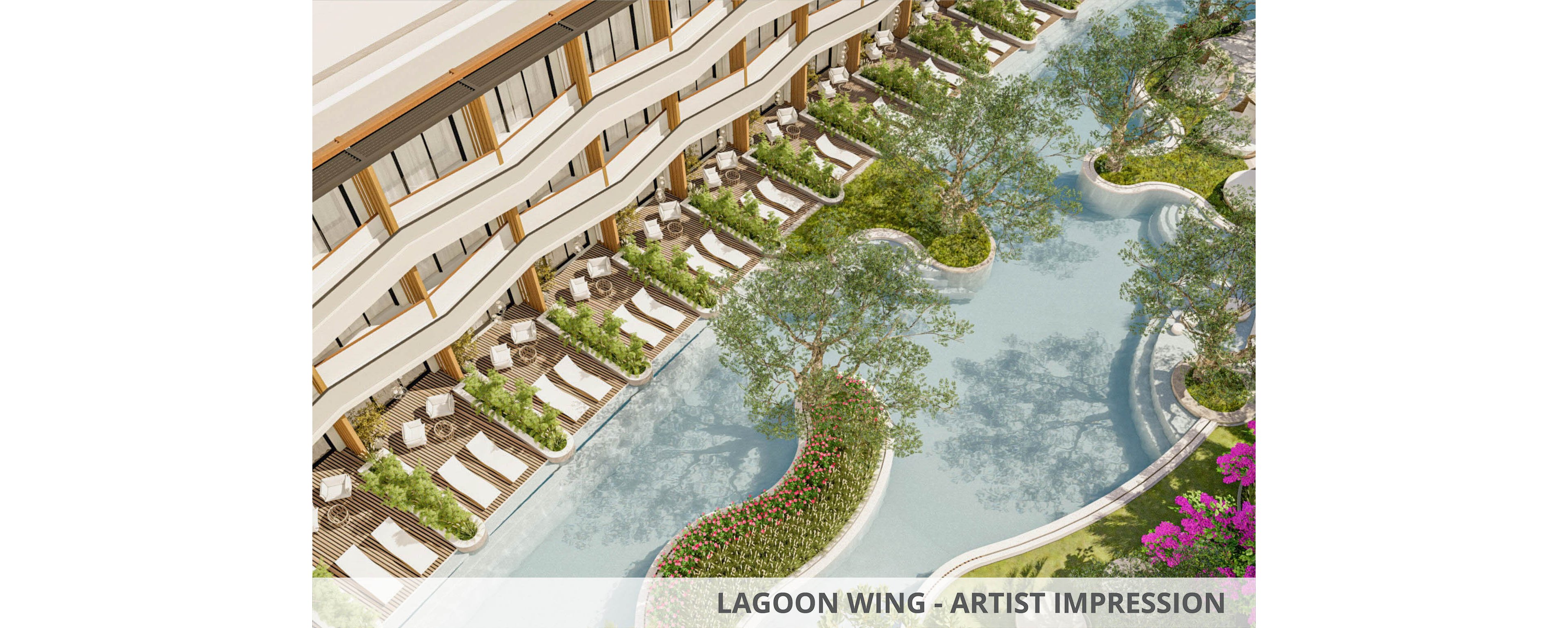 A contemporary resort features a long, curving pool surrounded by rows of white sun loungers and umbrellas. The multi-story building has balconies overlooking the water, creating a luxurious vacation setting. Trees and landscaped flower beds follow the pool’s organic shape, adding greenery and color. The overall scene suggests relaxation, leisure, and upscale outdoor living.
