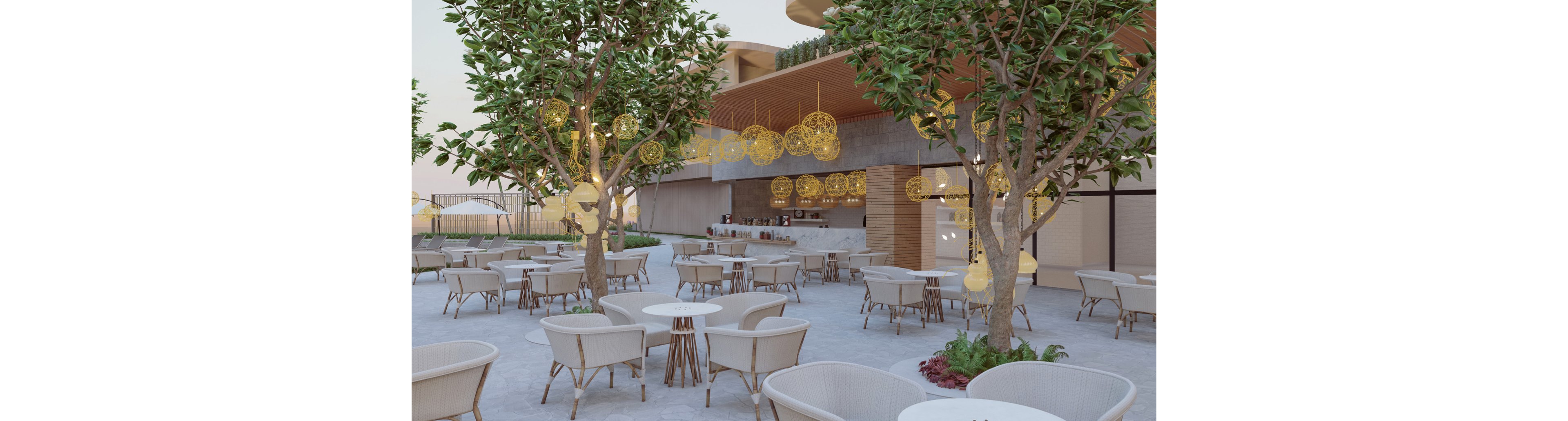 A contemporary outdoor café terrace features numerous round tables and woven chairs arranged beneath leafy trees. Warm decorative pendant lights hang from the ceiling above a sleek bar counter, creating an inviting atmosphere. The setting appears calm and spacious, with soft neutral tones and natural materials. In the background, architectural details and greenery enhance the modern, relaxed ambiance.