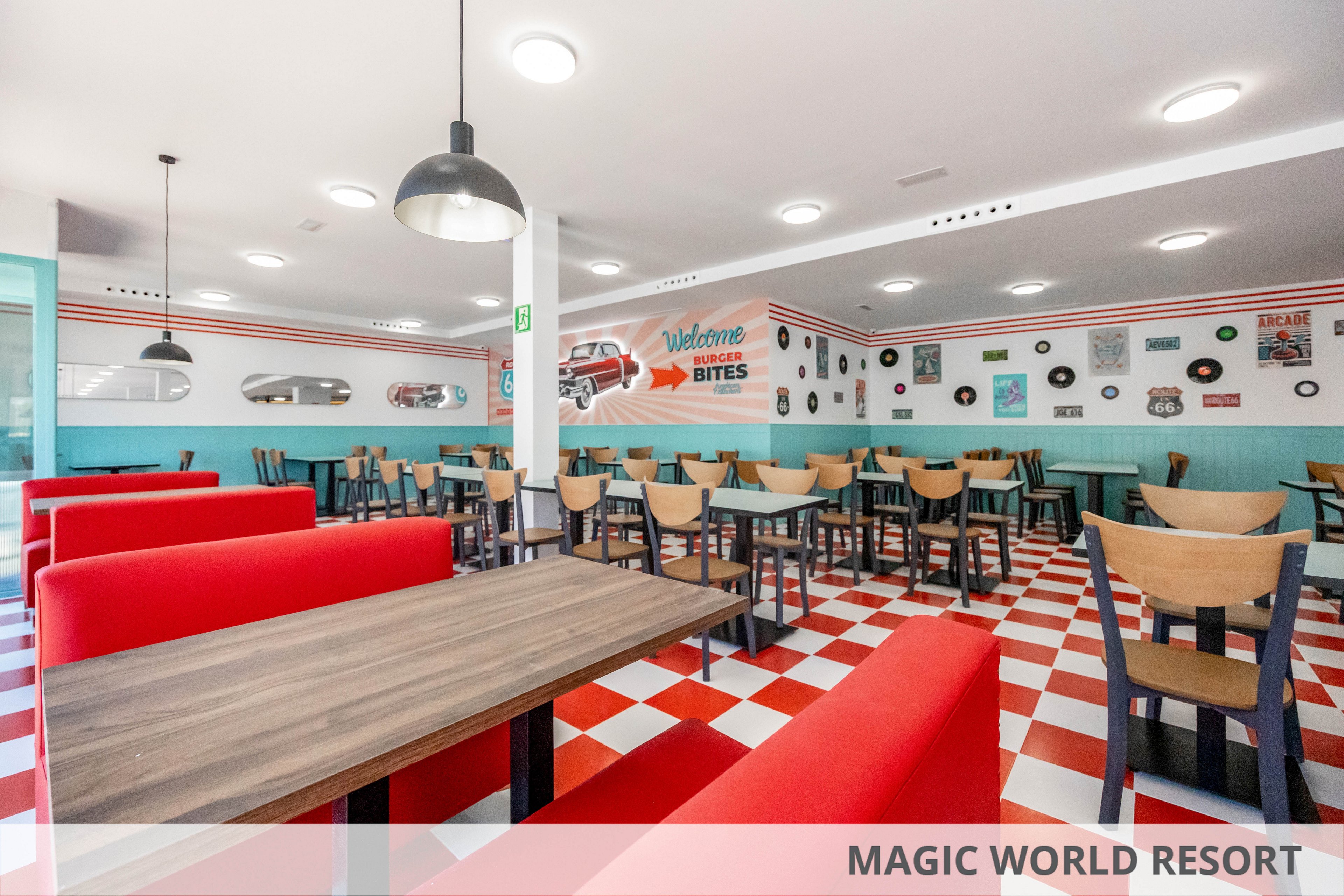 Bright retro-style diner interior featuring red booth seating and wooden tables. The space has a red and white checkered floor and light blue walls with vintage decor. Black pendant lights hang from the ceiling above the seating area. Wall art includes records, signs, and a large graphic with the words "Welcome" and "BITES". The restaurant appears clean, spacious, and ready for customers.