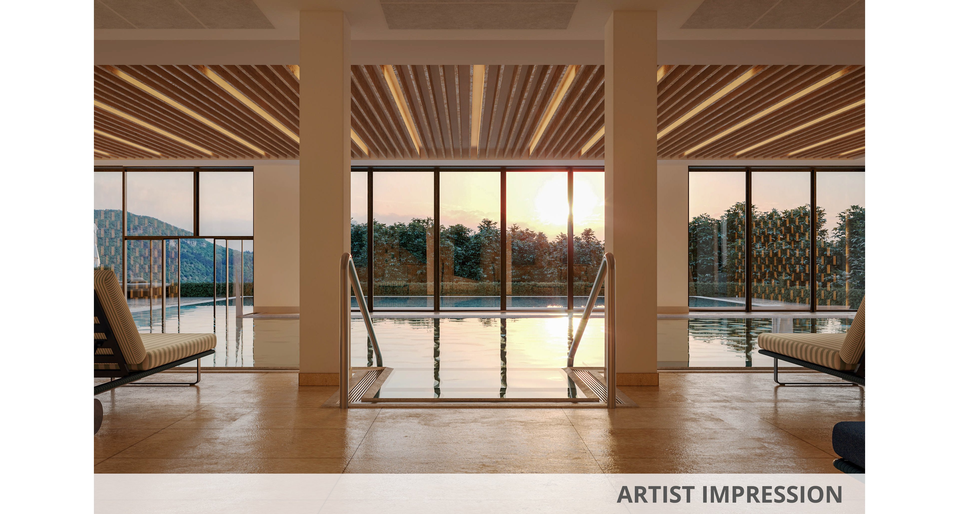 A serene indoor swimming pool is featured, surrounded by large glass windows that reveal a sunset view over trees and distant hills. Two cushioned lounge chairs are positioned on either side of the pool, inviting relaxation. The ceiling has a warm, wooden slat design, and the overall palette is neutral with golden sunlight streaming in. The tranquil setting suggests a luxury spa or hotel environment.