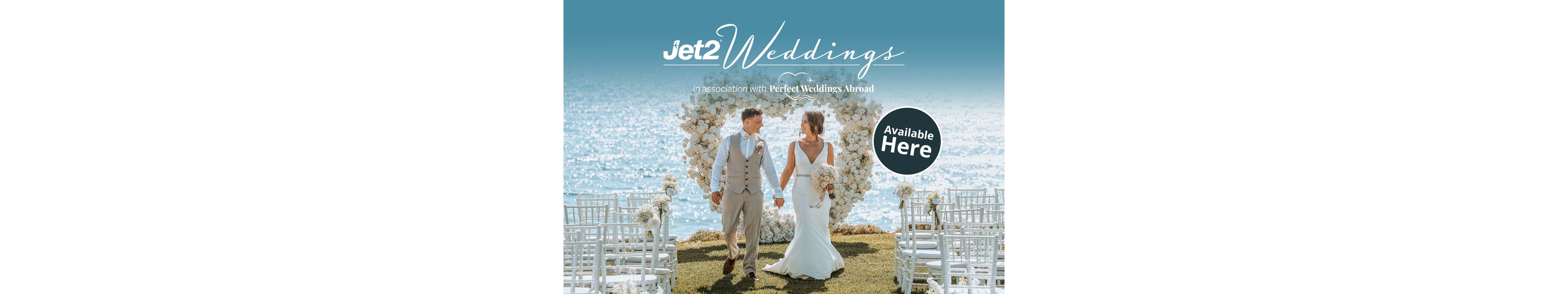 A bride and groom walk hand in hand at an outdoor seaside wedding ceremony. They are framed by a large white floral heart with rows of white chairs on either side. The bright blue ocean and sky create a romantic, sunlit backdrop. Text on the image reads "Jet2 Weddings", "In association with Perfect Weddings Abroad", and "Available Here".